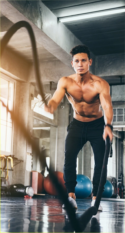 Een man doet een oefening met springtouwen in de sportschool